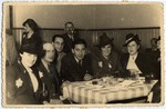 Group portrait of Jewish men and women in a cafe in the Lodz ghetto.