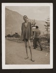 An emaciated survivor poses on a road in the Ebensee concentration camp two days after his liberation.