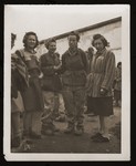 A group of female survivors stands outside a barracks in the newly liberated Lenzing concentration camp.