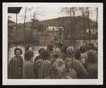 American Signal Corps photographer Sgt. Theodore Sizer of the 166th Signal Corps company, stands among a group of newly liberated, female survivors from Lenzing, a sub-camp of Mauthausen.