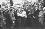 A group of German soldiers and civilians look on as a Jewish man is forced to cut the beard of another in Tomaszow Mazowiecki.
