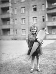 Portrait of a German Jewish girl holding a Schultüte [school cone] full of candy on her first day of school in Leipzig.