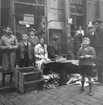 Vendors sell blocks of wood and kindling on the street in the Warsaw ghetto.