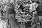 Jewish vendors sell vegetables at an open air market in the Warsaw ghetto.