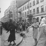 Vendors in the Warsaw ghetto hawk their goods to passing customers at the market on Krochmalna Street.