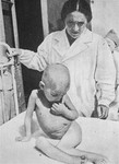 Dr. Anna Braude-Heller, the director of the Berson and Bauman Jewish Children's Hospital in the Warsaw ghetto, examines a starving child.