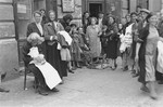 A group of Jewish vendors stand in the street outside a store in the Warsaw ghetto.