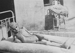 A starving child lies in a bed in a hospital in the Warsaw ghetto.