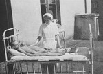 A nurse attends to two starving children in a hospital in the Warsaw ghetto.