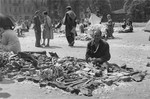 A Jewish vendor offers odds and ends for sale at an open air market in the Warsaw ghetto.