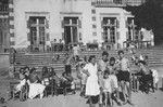 Jewish refugee children and staff members of the Chabannes children's home relax in the sun outside the home.