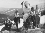 Four friends build a snowman in the Czech mountains.
