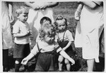 A group of pre-school age children stand in a field at a Jewish displaced persons camp in Austria (probably Bindermichl).