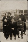 Seven young people pose in front of the Jewish Youth Library in Eisiskes.