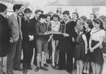 A British sailor shows George Spiegelglas and a group of other school-children a model of a ship.