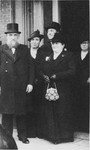 Rabbi Eliyahu Frances, chief rabbi of the Portuguese Synagogue in Amsterdam, and his wife Diamante Tazartes stand in front of a group of people leaving the synagogue.