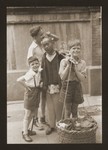 A Chinese street peddler stands with three Jewish refugee boys.