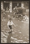 Harry Fiedler plays in the water of a flooded street [Tongshan Road] in Shanghai.