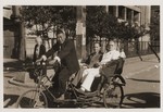 Two Jewish refugees ride in a pedicab.