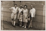 Members of the Goldstaub family pose with Harry Fiedler on a street in Shanghai.