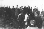 A crowd of people observes the exhumation of a mass grave in the Jewish cemetery of Stanislawow.