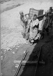Prisoners in Plaszow transport a food container to others at forced labor.