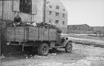 Jewish prisoners load textiles onto a truck from a Madritch factory warehouse.