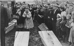 Two women grieve over the coffins of those killed in the Kielce pogrom as they are transported to the burial site in the Jewish cemetery.