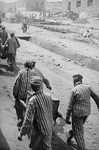 Prisoners in Plaszow carry food containers to a work site where it will be distributed.