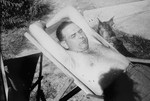 Commandant Amon Goeth relaxes in a lawn chair at his villa in the Plaszow concentration camp with his dog Ralf.