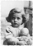 Portrait of Basia Israel clutching a doll in the Krakow ghetto.
