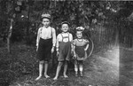 Three Jewish children pose outside in Veliki Palad.