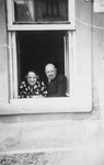 Portrait of the donor's parents, Jakub and Lilly Herzog, looking out of a window of their home in Hlohovec, Czechoslovakia.