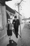 Portrait of the donor's parents, Jakub and Lilly Herzog, walking  along the sidewalk in front of their home in Hlohovec, Czechoslovakia.