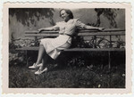 A young Jewish woman relaxes on an outdoor bench in Mirabeau, France.