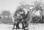 Magdalena, Paul-Gerhard, and Elisabeth attend to a lamb in the yard of the Kusserow family home in Bad Lippspringe.