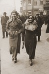Ita Rozencwajg and her cousin Frieda walk down a street in Warsaw.