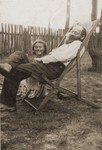 Ita Rozencwajg sits outside in the yard with her uncle Mendel Miodownik while on a visit to Minsk Mazowiecki.