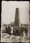 Haika Grosman poses with a group of survivors in front of a memorial to the Jews of Bialystok.