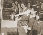 Jewish women liberated from a factory in Mehlteuer are given food seized from Nazi warehouses.