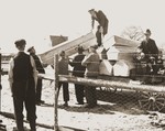 German civilians from Schwarzenfeld load a wagon with coffins to be transported to a mass grave from which the bodies of 140 Hungarian, Polish, and Russian Jews were exhumed.