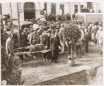 Under the supervision of American soldiers, German civilians bury the bodies of 71 political prisoners, exhumed from a mass grave near Solingen-Ohligs, in front of the city hall.