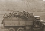 A truckload of displaced persons and concentration camp survivors are transported through the German countryside by American soldiers.