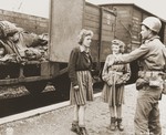 Pfc. Andrew E. Dubill speaks with two Jewish girls who were held prisoner by the SS.