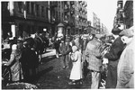 Jews move along a crowded street in the Warsaw ghetto.