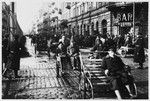 Bicycle-powered rickshaws transport Jews down a crowded street in the Warsaw ghetto.