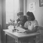 Margot Stein and Mrs. Zimmer, the wife of a physician of the Unitarian Service Committee, examine a document in their office at the Hotel Bompard internment camp.