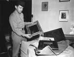 Captain Fred Levy of Dallas, TX opens packages containing art work looted by the Nazis for the private collection of Joseph Goebbels.