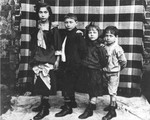 The four Goldfajs siblings pose in front of a blanket at their home in Warsaw.