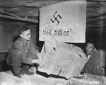 Two soldiers of the 90th Division, U.S. Third Army, remove a crate containing looted historical engravings that were discovered in the Merkers salt mine.